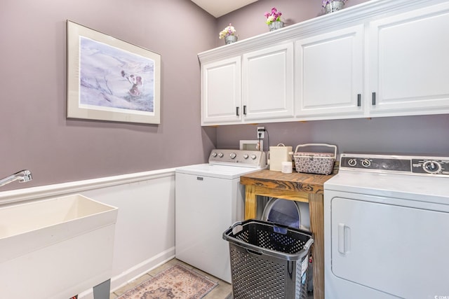 laundry area with a sink, cabinet space, washing machine and dryer, and light tile patterned floors