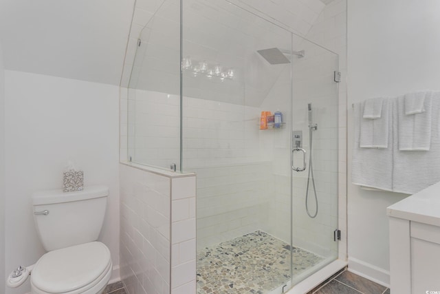 bathroom featuring vanity, baseboards, a stall shower, tile patterned flooring, and toilet