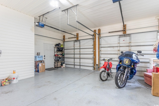 garage featuring a garage door opener and metal wall