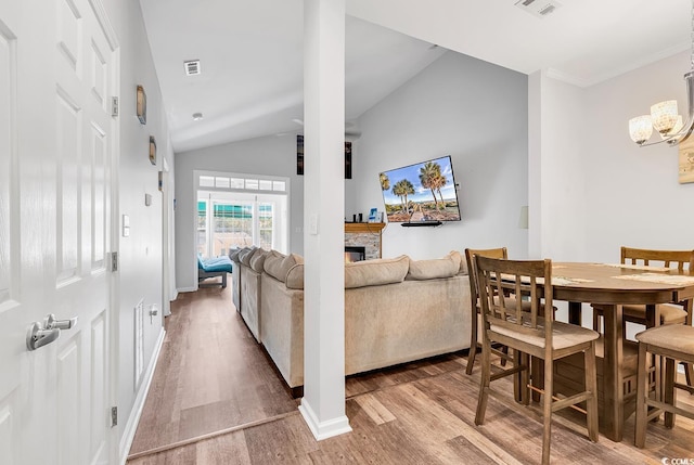 interior space featuring a stone fireplace, hardwood / wood-style flooring, and vaulted ceiling