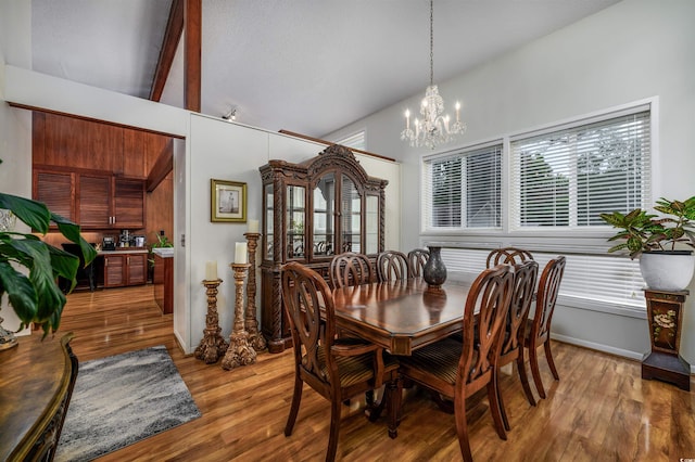 dining room featuring beamed ceiling, a notable chandelier, hardwood / wood-style floors, and high vaulted ceiling