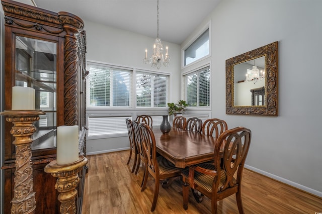 dining space featuring an inviting chandelier, wood-type flooring, and a healthy amount of sunlight