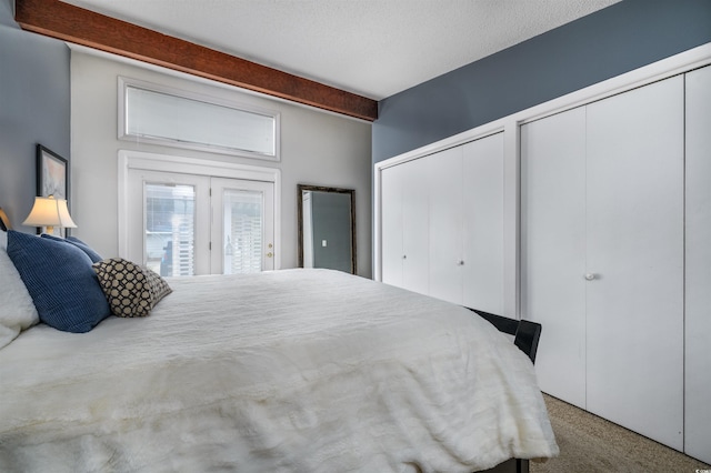 carpeted bedroom featuring multiple closets and a textured ceiling