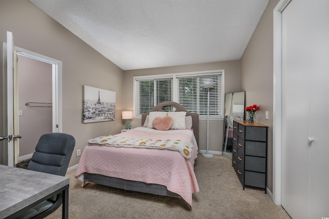 carpeted bedroom featuring a textured ceiling and lofted ceiling