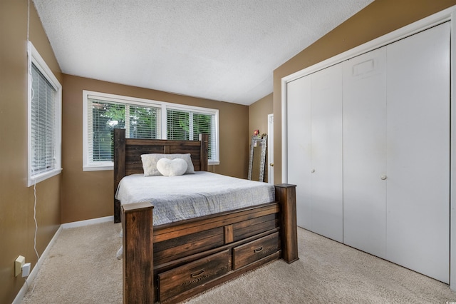 bedroom with light carpet and a textured ceiling