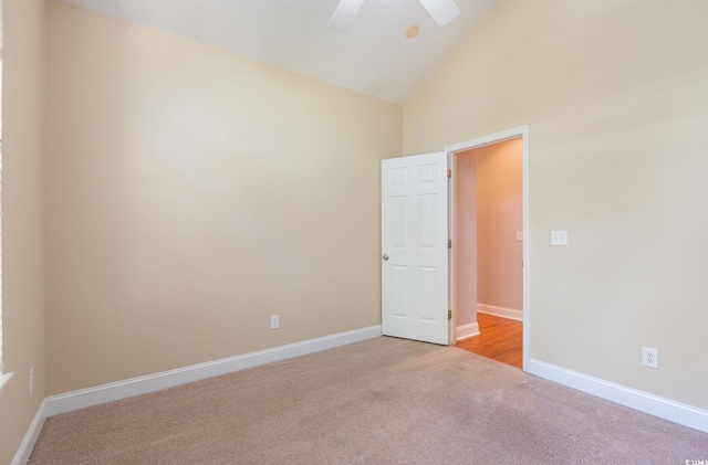 empty room with light colored carpet, high vaulted ceiling, and ceiling fan