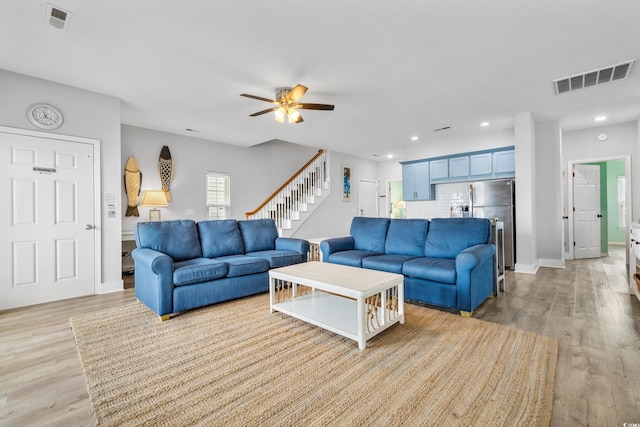 living room featuring light hardwood / wood-style floors and ceiling fan