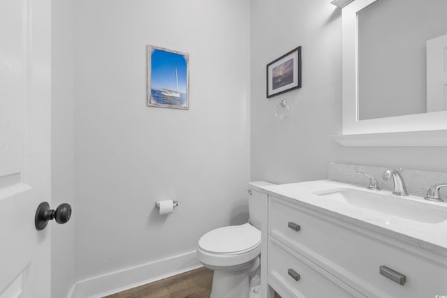 bathroom with hardwood / wood-style floors, vanity, and toilet