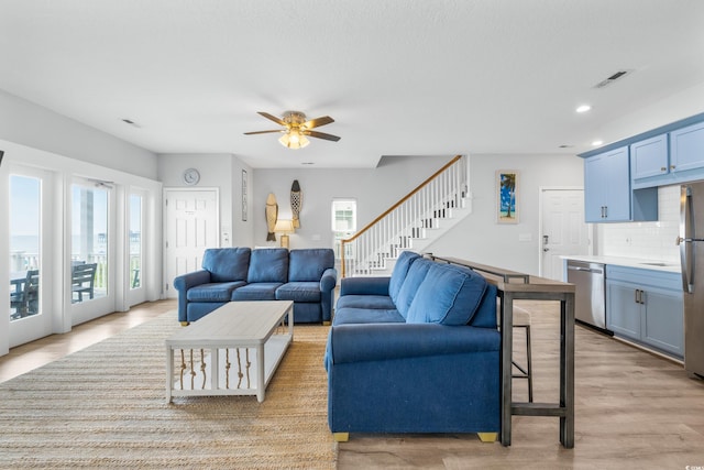 living room featuring light wood-type flooring and ceiling fan