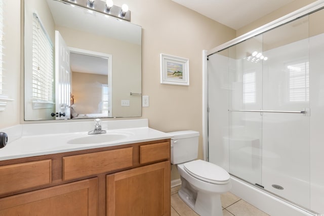 bathroom with vanity, toilet, a shower with door, and tile patterned floors