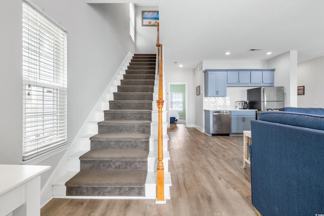 stairs featuring hardwood / wood-style floors and a wealth of natural light