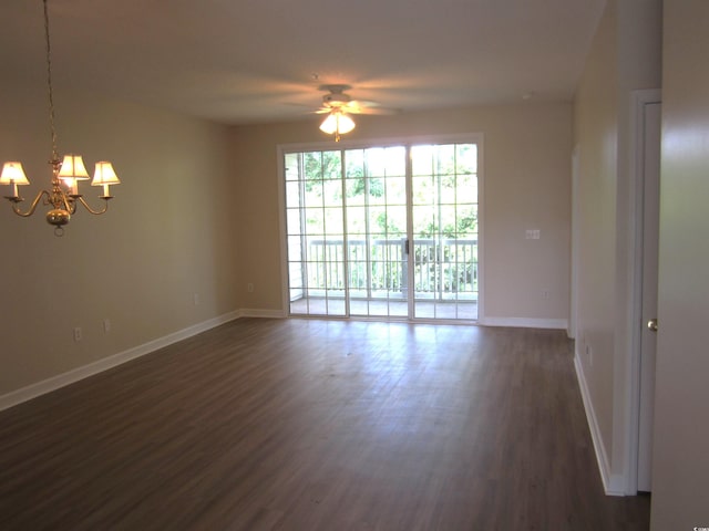 empty room with ceiling fan with notable chandelier and dark hardwood / wood-style flooring