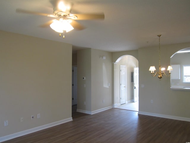 unfurnished room with ceiling fan with notable chandelier and hardwood / wood-style flooring