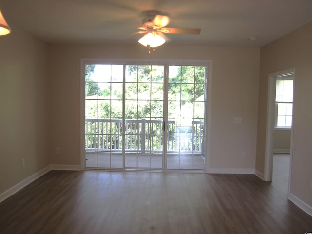 empty room with dark hardwood / wood-style flooring and ceiling fan