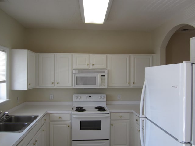 kitchen featuring white cabinets, white appliances, and sink