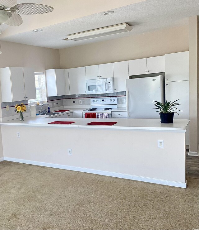 kitchen with white cabinetry, sink, light hardwood / wood-style floors, and white appliances