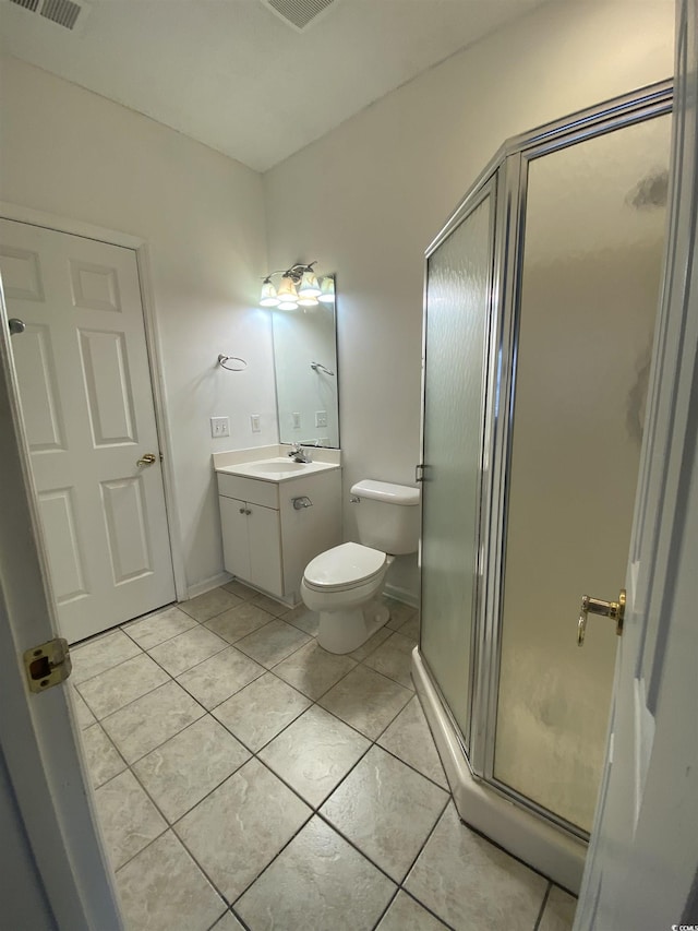 bathroom with baseboards, toilet, tile patterned flooring, vanity, and a shower stall