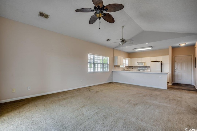 unfurnished living room with lofted ceiling, light carpet, visible vents, and baseboards