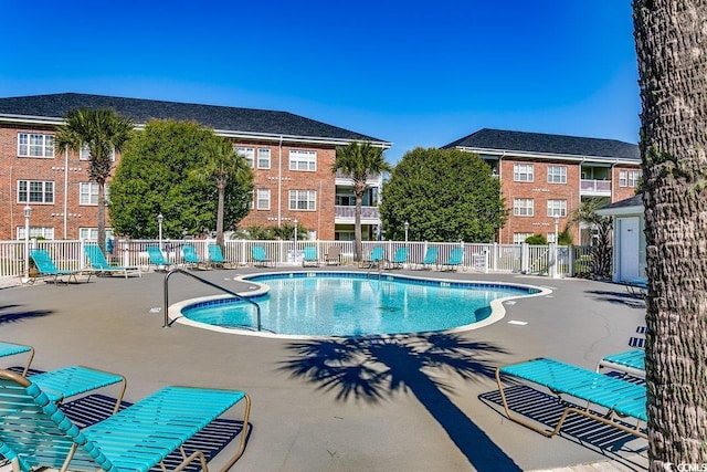 community pool featuring fence and a patio