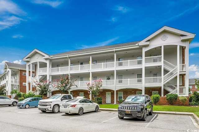 view of building exterior featuring uncovered parking and stairway