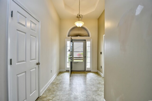 tiled entryway featuring a tray ceiling