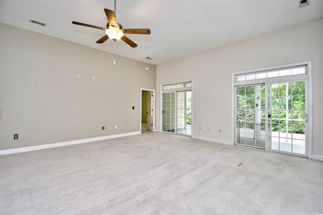 carpeted spare room with a high ceiling, french doors, ceiling fan, and a healthy amount of sunlight