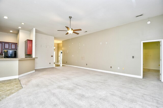 unfurnished living room featuring ceiling fan and carpet