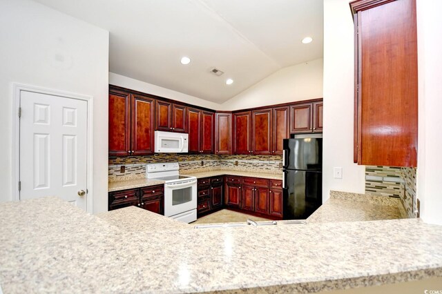 kitchen featuring backsplash, white appliances, and vaulted ceiling