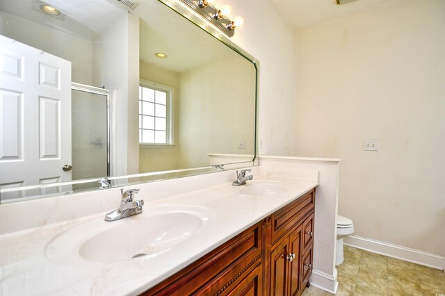 bathroom with vanity, toilet, tile patterned floors, and a shower with door