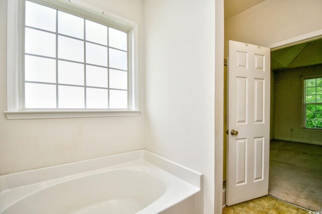 bathroom with tile patterned floors and a bathtub