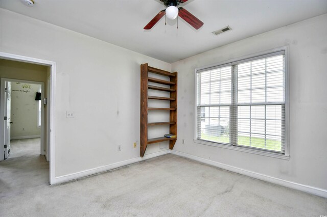 spare room featuring light colored carpet and ceiling fan