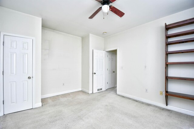 unfurnished bedroom featuring light colored carpet and ceiling fan