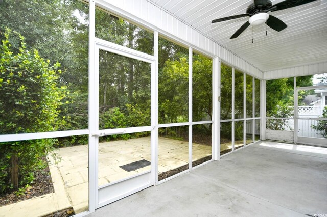 unfurnished sunroom with ceiling fan