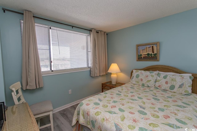 bedroom with a textured ceiling and hardwood / wood-style flooring