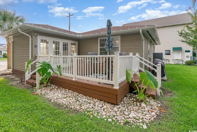 back of house featuring a wooden deck and a lawn