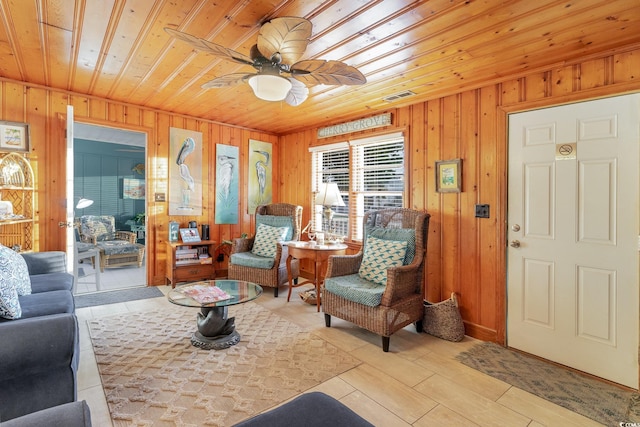 tiled living room with wood walls, wood ceiling, and ceiling fan