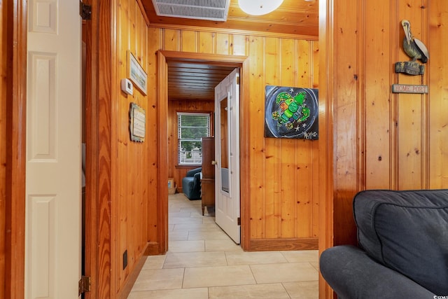 hallway featuring wood walls and light tile patterned floors