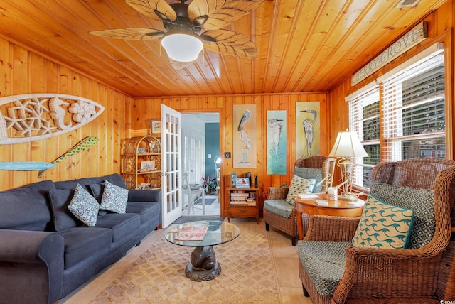 living room featuring ceiling fan, wooden walls, and wooden ceiling