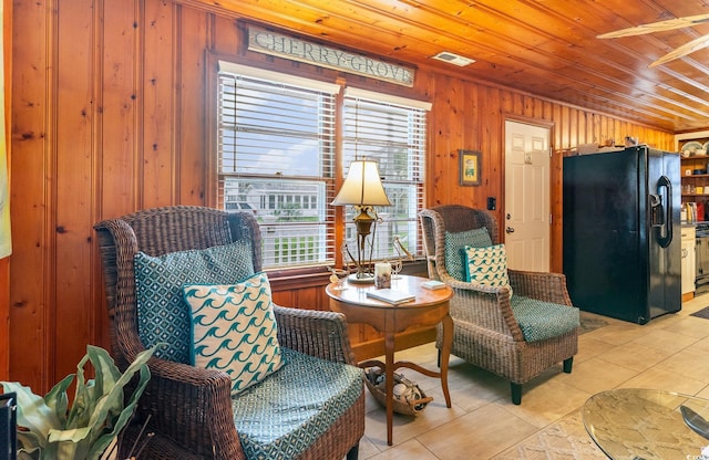 living area with wood ceiling, wood walls, and light tile patterned floors