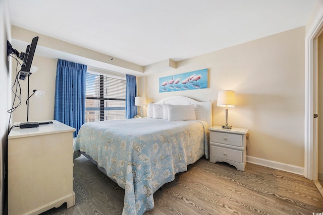 bedroom featuring baseboards and wood finished floors