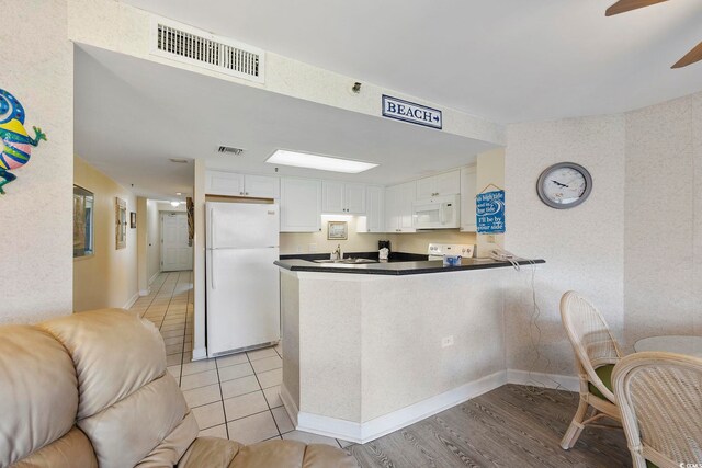 kitchen featuring kitchen peninsula, white appliances, ceiling fan, and white cabinetry