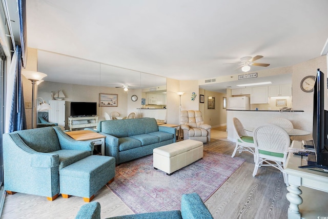 living room featuring hardwood / wood-style floors and ceiling fan