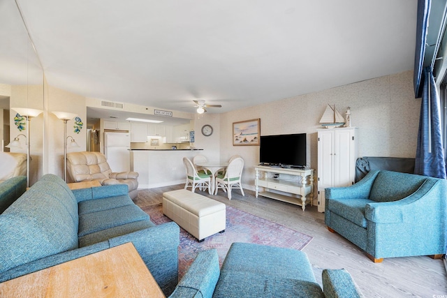 living room featuring ceiling fan and light hardwood / wood-style flooring