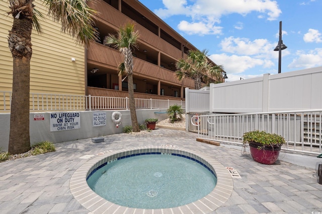 view of swimming pool featuring a community hot tub and a patio