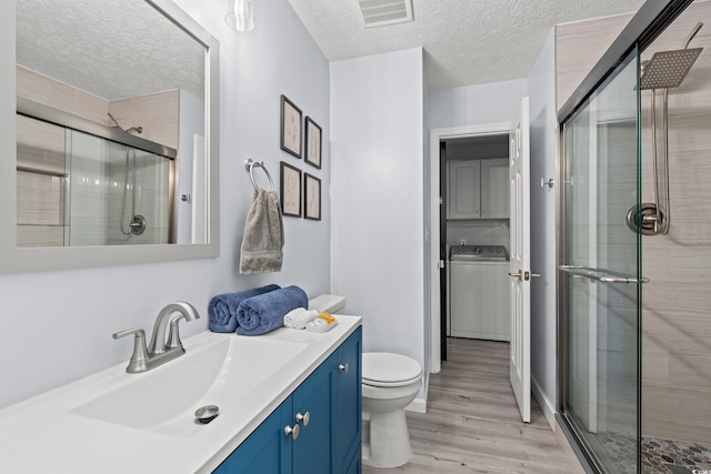 bathroom with vanity, a textured ceiling, wood-type flooring, toilet, and an enclosed shower