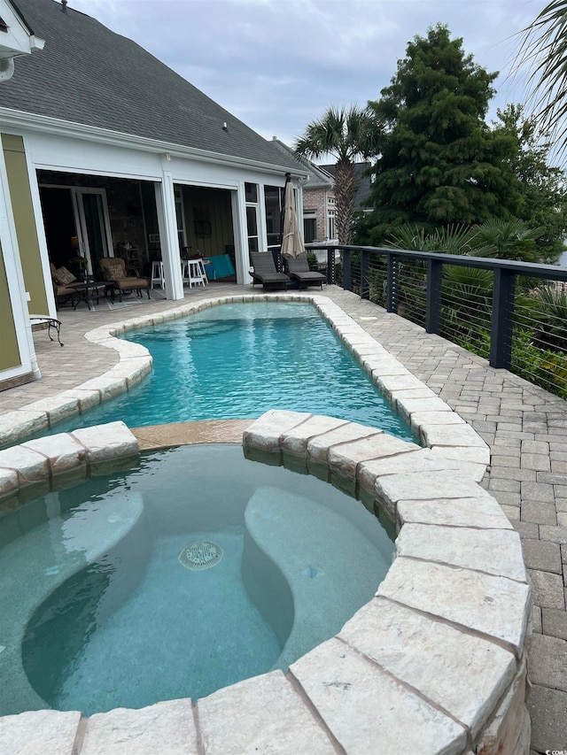 view of pool with a patio and an in ground hot tub