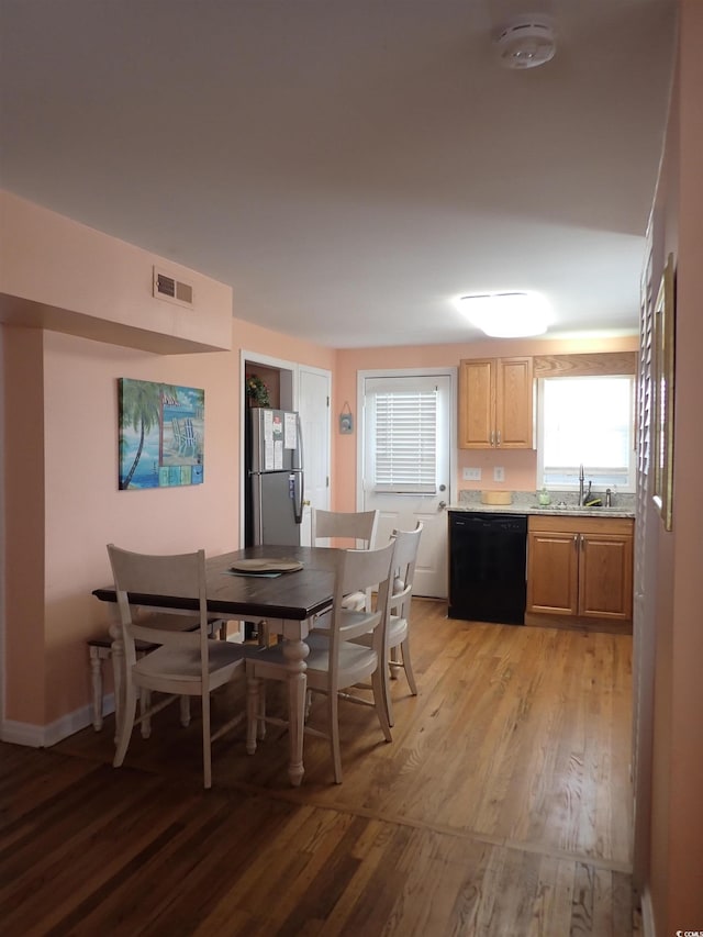 dining space featuring light wood-type flooring and sink