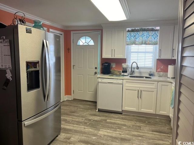 kitchen featuring white cabinets, stainless steel fridge, sink, dishwasher, and light wood-type flooring