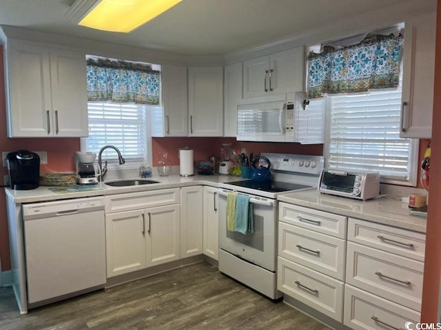 kitchen featuring white appliances, white cabinetry, sink, and dark hardwood / wood-style flooring