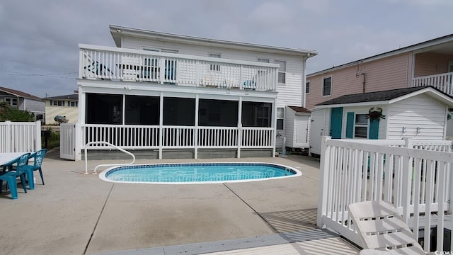 view of pool featuring a sunroom and a patio area